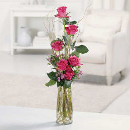 Tall pink rose arrangement in a clear glass vase