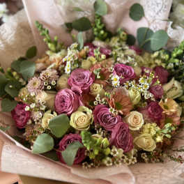 Bouquet of pink and cream roses with small white filler flowers