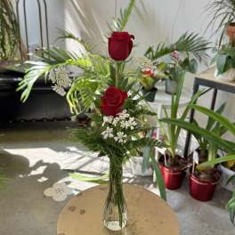 Tall glass vase with two red roses and white filler flowers