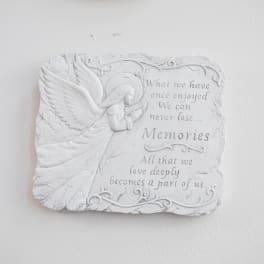 White memorial plaque with an angel and engraved quote