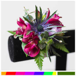 Magenta floral wrist corsage with purple accents on a black band