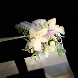 Small wrist corsage with white and pale pink flowers on a ribbon band