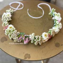 Floral crown with white and pink flowers on a round table