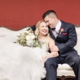 Bride and groom seated with a white bridal bouquet
