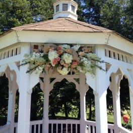 Floral arrangement of white and pink blooms on a white gazebo