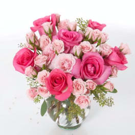 Pink and blush roses arranged in a clear glass vase