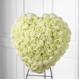 Heart-shaped arrangement of white roses on a stand