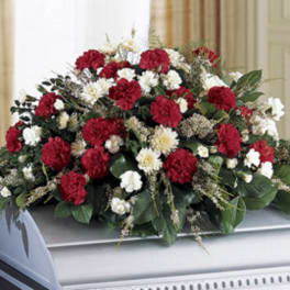 Red and white floral casket spray on a silver casket