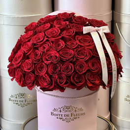 Round box of red roses with a ribbon bow