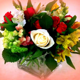 Mixed bouquet with red and white roses in a clear glass vase