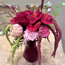 Bouquet of magenta and pink flowers in a dark vase