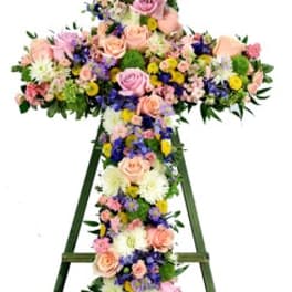Floral cross on a standing easel with pastel roses and mixed blooms