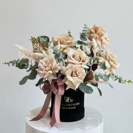 Peach roses in a black hatbox with pink ribbon
