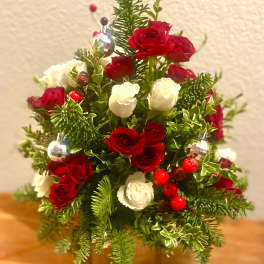Red and white rose arrangement with holiday ornaments in a vase
