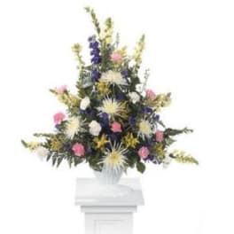 Tall mixed floral arrangement in a white vase with pink, purple, and white blooms
