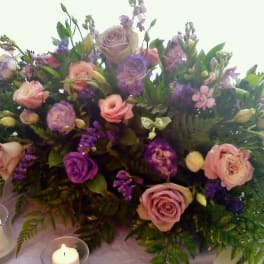 Large bouquet of pink and purple roses with candles