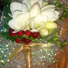 White calla lily bouquet with red berries and a gold ribbon