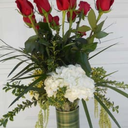 Tall bouquet of red roses and white hydrangeas in a glass vase