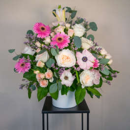 Pink and white mixed flower arrangement in a white vase