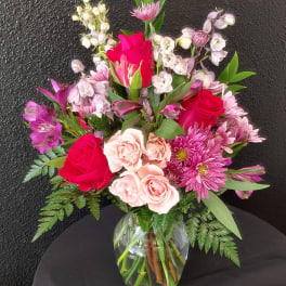 Mixed pink and red bouquet in a clear glass vase