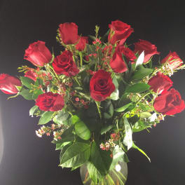 Red roses arranged in a clear glass vase