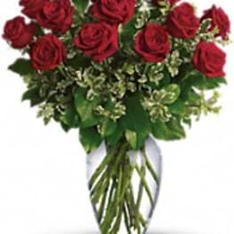 Red roses arranged in a clear glass vase