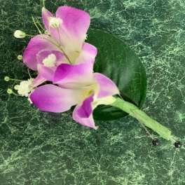 Pink and white calla lily corsage on a green marbled background