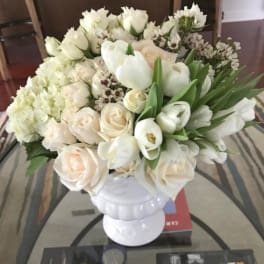 White floral arrangement in a white pedestal vase