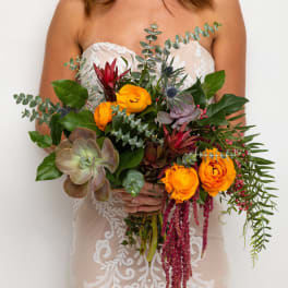 Bride holding a bouquet with orange flowers and succulents