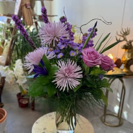 Purple and pink mixed bouquet in a clear glass vase