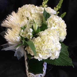 White floral bouquet with hydrangeas and spider mums in a decorative vase