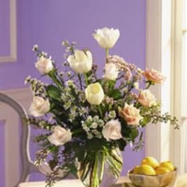 Mixed bouquet of white and peach flowers in a glass vase