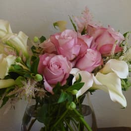 Pink roses and white calla lilies in a glass vase
