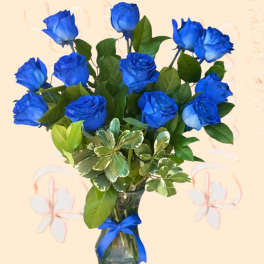 Blue roses in a glass vase with a ribbon