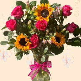 Bouquet of pink roses and sunflowers in a glass vase with a pink ribbon