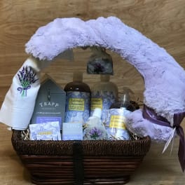 Lavender-themed gift basket with plush blanket and bath products