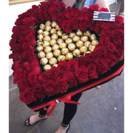 Heart-shaped box of red roses with gold-wrapped chocolates