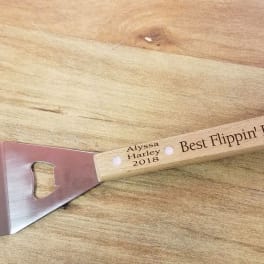 Personalized metal spatula with wooden handle on a table
