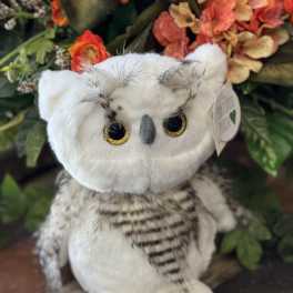 Plush owl in front of a floral arrangement