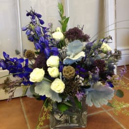 Blue and white floral arrangement in a square glass vase
