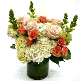 Pink roses and white hydrangeas in a green glass vase