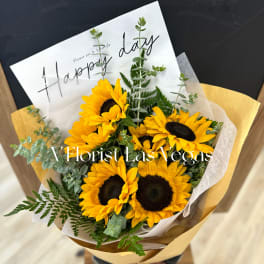 Bouquet of yellow sunflowers wrapped in paper