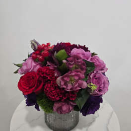 Mixed pink, red, and purple bouquet in a silver vase
