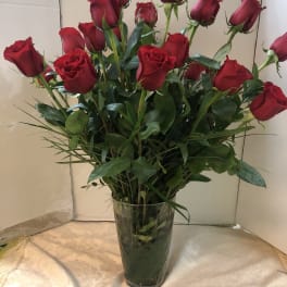 Red roses arranged in a clear glass vase