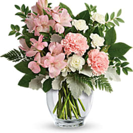 Pink and white flowers arranged in a clear glass vase