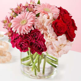 Pink and red mixed bouquet in a clear glass vase
