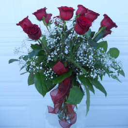 Bouquet of red roses with white baby's breath in a glass vase