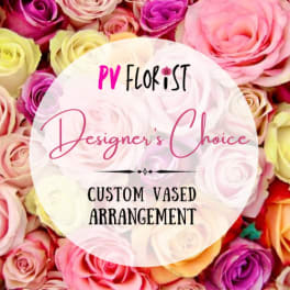 Assorted roses with a circular label reading "Designer’s Choice"