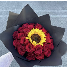 Bouquet of red roses with a yellow sunflower in black wrap