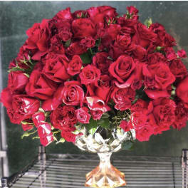 Large dome of red roses in a faceted glass pedestal vase